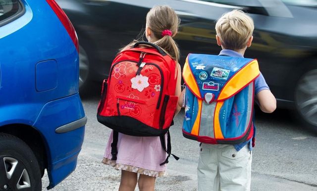 Je mehr Autos vor dem Schulhaus sind, desto unübersichtlicher und gefährlicher wird es: Zwei Kinder auf dem Weg zur Schule. (Symbolbild)