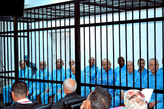 The defendants attended the hearings locked in a cage.