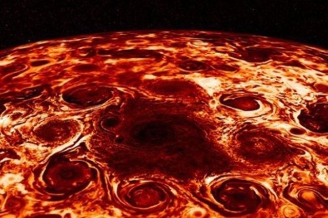Vue de l'espace, Jupiter est divisée en bandes horizontales de couleurs chaudes, qui tournent à des vitesses différentes. Ces bandes sont créées par des couronnes de vents intenses circulant alternativement vers l'est et vers l'ouest. 