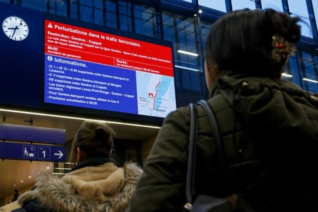 Des passagers des CFF regardent les panneaux indicateurs de la gare CFF de Cornavin annonçant des retards et des suppressions de trains suite à un accident de personne.