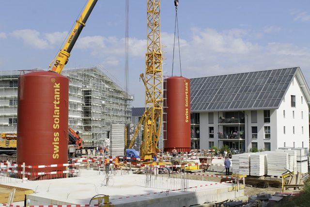 Im Juni wurden die zehn Meter hohen Solartanks für die neuen Mehrfamilienhäuser in Oberburg gesetzt, rechts das 2007 gebaute Haus.