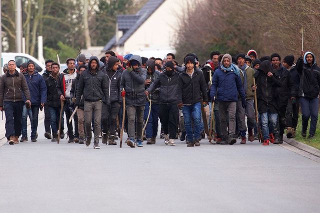 Nie dagewesener Grad der Gewalt. Eine Gruppe Migranten läuft mit Stöcken bewaffnet durch Calais.